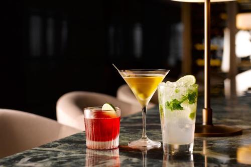 three cocktails sitting on a table in a restaurant at Hotel Onoma Daejeon, Autograph Collection in Daejeon