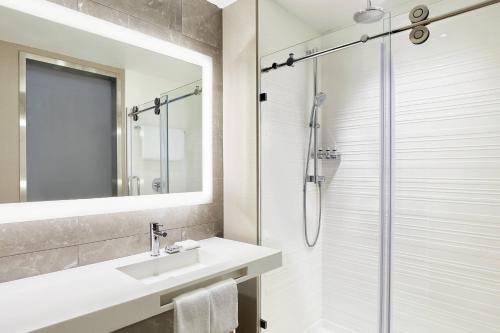 ein Bad mit einem Waschbecken und einer Dusche in der Unterkunft AC by Marriott Hotel Huntsville Downtown in Huntsville
