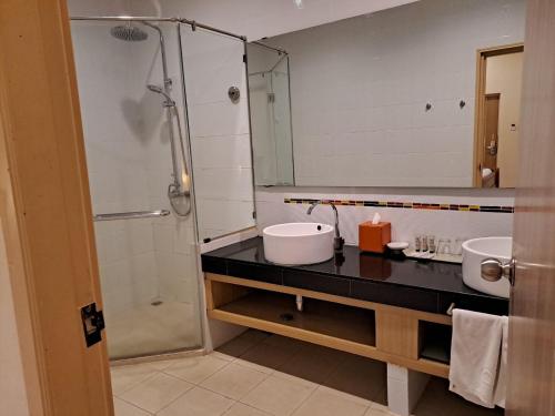 een badkamer met een wastafel en een douche met een spiegel bij PM Lake Mabprachan Pattaya in Ban Pong