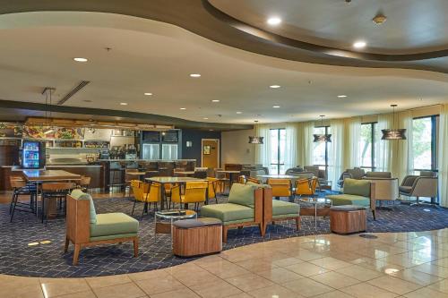 a lobby with tables and chairs and a bar at Courtyard Medford Airport in Medford