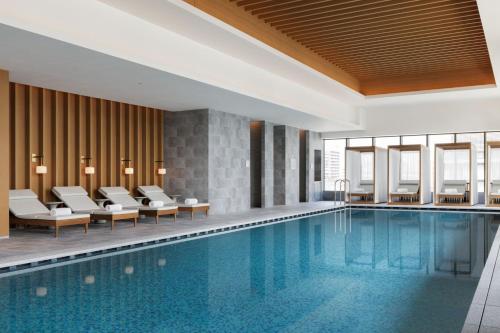 a pool in a hotel room with chairs and tables at The Westin Yokohama in Yokohama