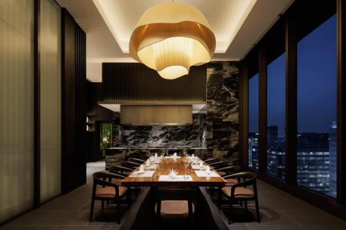 a dining room with a long table and a chandelier at The Westin Yokohama in Yokohama