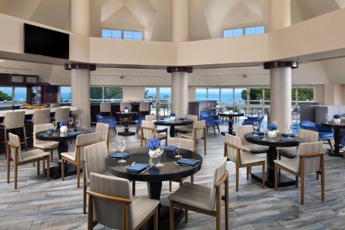 un restaurante con mesas y sillas y un bar en Laguna Cliffs Marriott Resort & Spa, en Dana Point