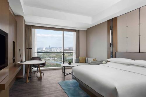 a hotel room with a bed and a large window at Jiaxing Marriott Hotel in Jiaxing