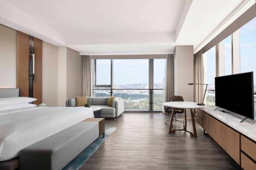 a hotel room with a bed and a flat screen tv at Jiaxing Marriott Hotel in Jiaxing