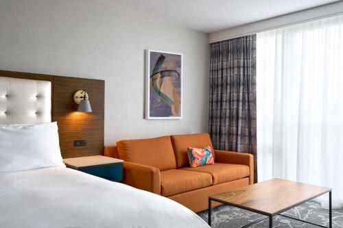 a hotel room with a bed and a couch at Renaissance Meadowlands Hotel in Rutherford