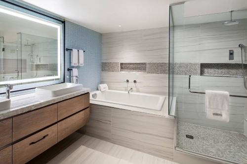 y baño con bañera, lavamanos y ducha. en Laguna Cliffs Marriott Resort & Spa en Dana Point