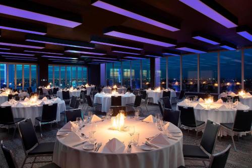 a banquet hall with white tables and chairs and windows at Aloft Perth in Perth