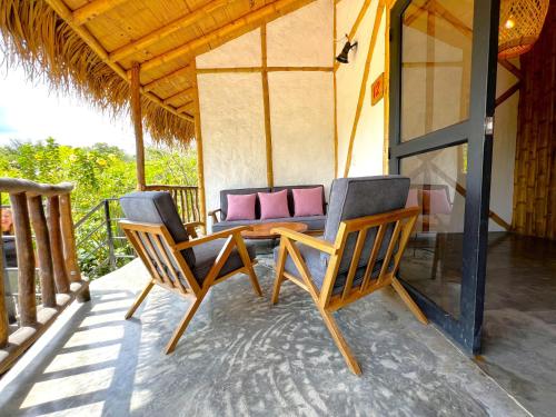 a pair of chairs and a table on a porch at Ceiba by Masaya Collection in San Agustín