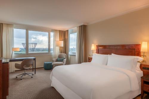 een hotelkamer met een groot bed en een bureau bij The Westin Grand Munich in München