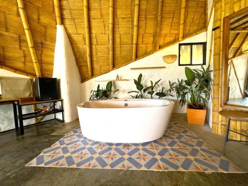 a large bathroom with a tub and plants in it at Ceiba by Masaya Collection in San Agustín