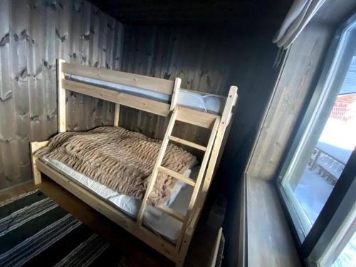 a bunk bed in a room next to a window at Cosy apartment with ski in/out in Noresund