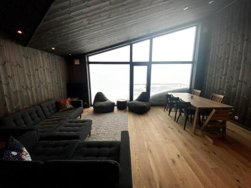 a living room with couches and a table and a large window at Cosy apartment with ski in/out in Noresund