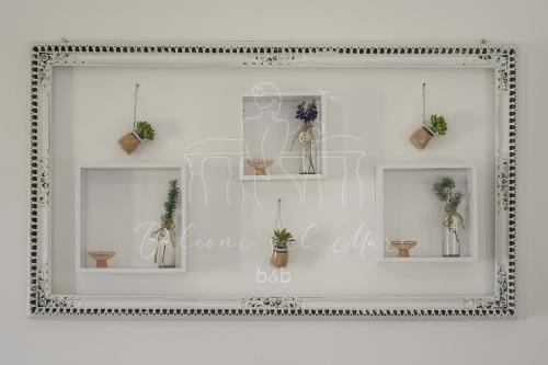 a mirror with three pictures of vases and plants at Balconi sul mare in Otranto