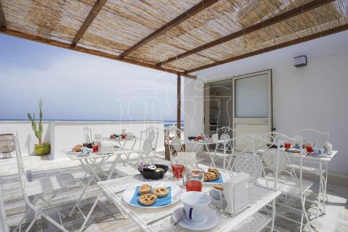 una sala da pranzo con tavolo e cibo di Balconi sul mare a Otranto