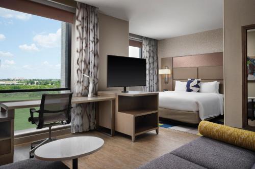 a hotel room with a bed and a large window at Residence Inn by Marriott Dallas Frisco in Frisco