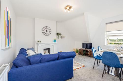 a blue couch in a living room with a table at Beautiful newly refurbished apartment close to the promenade. in Llandudno
