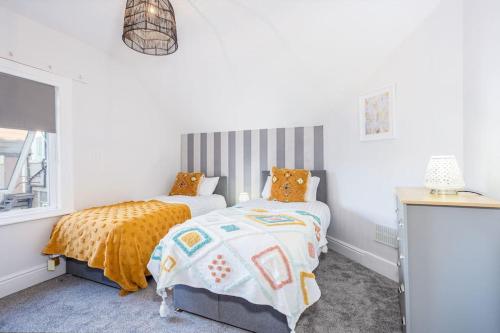 um quarto com 2 camas e uma janela em Beautiful newly refurbished apartment close to the promenade. em Llandudno
