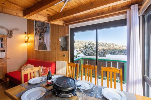 ボルケール・ピレネー 2000にあるChalet les Lupins Bleus au pied des pistes Font-Romeu Pyrénées 2000のテーブルと大きな窓のあるダイニングルーム