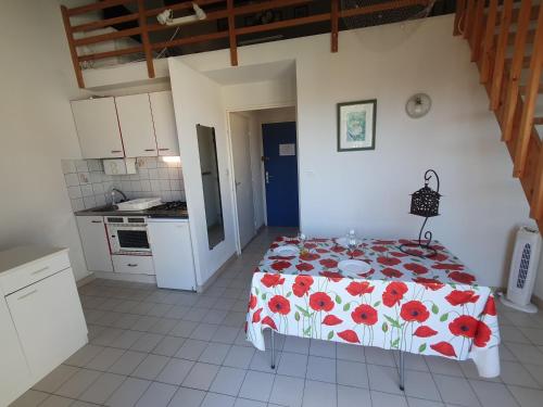 une chambre avec un lit avec un couvre-lit fleuri dans l'établissement JEAN BART III Joli 2 pièces cabine mezzanine Richelieu Cap d'Agde, au Cap d'Agde