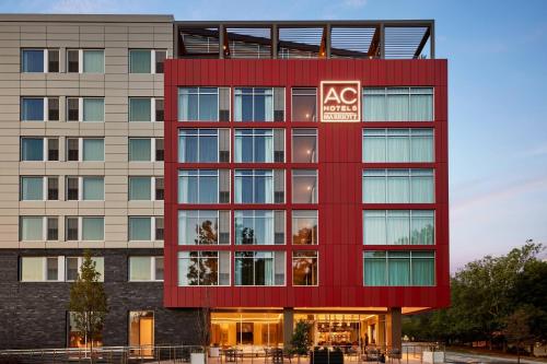 um edifício vermelho com um sinal de benefício em AC Hotel by Marriott Atlanta Perimeter em Atlanta