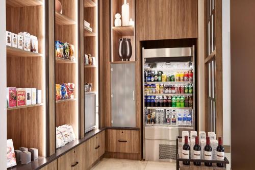 a kitchen with a refrigerator filled with lots of drinks at AC Hotel by Marriott Atlanta Perimeter in Atlanta