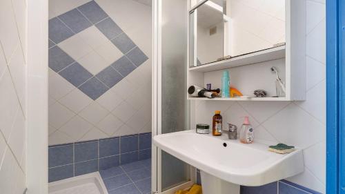 une salle de bain avec un lavabo et un miroir dans l'établissement Pre St Martin- 3B- Studio loggia vitree- 4 pers, au Cap d'Agde