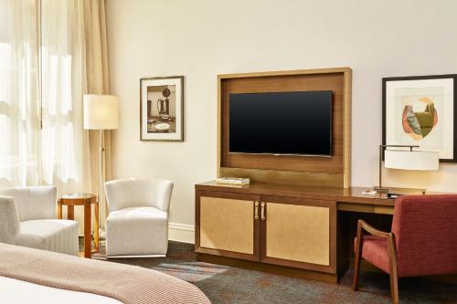 a hotel room with a television on a desk and chairs at Palace Hotel, a Luxury Collection Hotel, San Francisco in San Francisco