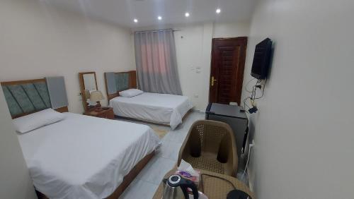 カイロにあるRamses Guest Houseのベッド2台とテレビが備わるホテルルームです。