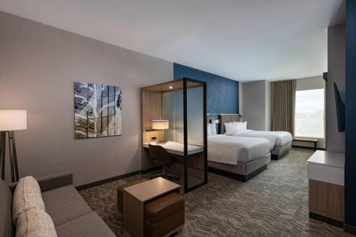 une chambre d'hôtel avec deux lits et un canapé dans l'établissement SpringHill Suites Waco, à Waco