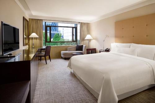 a hotel room with a large bed and a living room at Westin Josun Seoul Hotel in Seoul