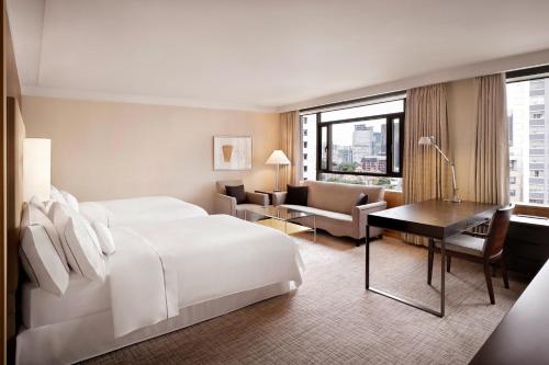 una camera d'albergo con letto bianco e scrivania di Westin Josun Seoul Hotel a Seul