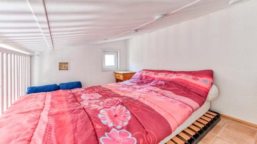 une chambre avec un lit avec une couverture rose dans l'établissement Les 4 Soleils- 16AB- Studio moderne- 4pers, au Cap d'Agde