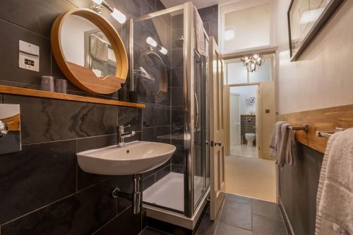 a bathroom with a sink and a shower and a mirror at Bath View Apartments in Bath