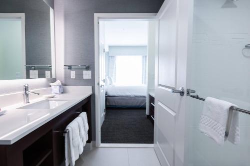 Baño blanco con lavabo y espejo en Residence Inn by Marriott Oklahoma City Airport en Oklahoma City