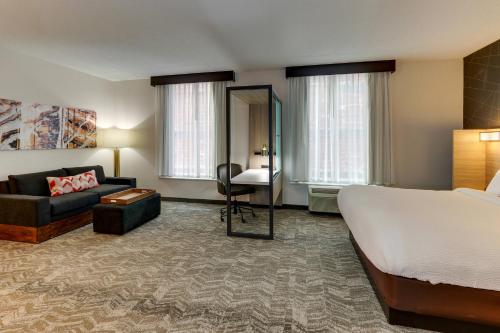 バーミングハムにあるSpringHill Suites by Marriott Birmingham Downtown at UABのベッド、ソファ、デスクが備わるホテルルームです。