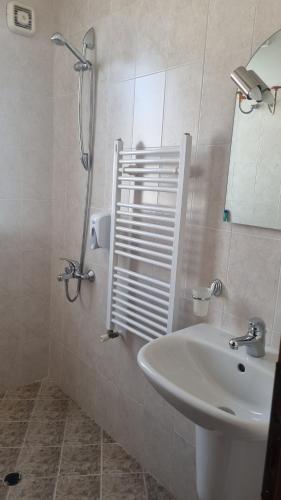 a bathroom with a sink and a mirror and a shower at Банско Апартментс in Bansko