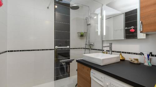 une salle de bain avec un lavabo et un miroir dans l'établissement Neptuna- 217L- Appart charme- 6 pers, au Cap d'Agde
