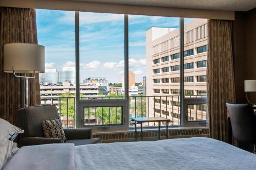 een hotelkamer met een bed en een groot raam bij Sheraton Cavalier Saskatoon Hotel in Saskatoon