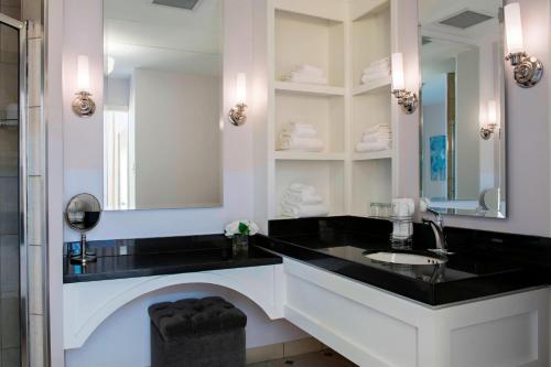 a bathroom with a sink and a mirror at Sheraton Cavalier Saskatoon Hotel in Saskatoon