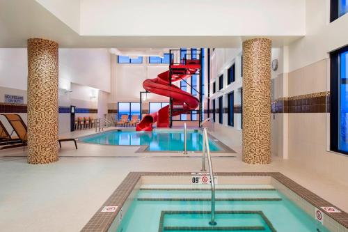 a indoor swimming pool with a slide in a building at Courtyard by Marriott Calgary South in Calgary