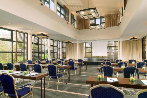 a restaurant with tables and chairs and windows at The Westin Grand Berlin in Berlin