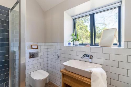 a white bathroom with a sink and a toilet at Green End Farm Cottages - The Sheep Shed in Whitby
