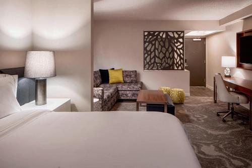 a hotel room with a bed and a living room at The Westin Oaks Houston at the Galleria in Houston