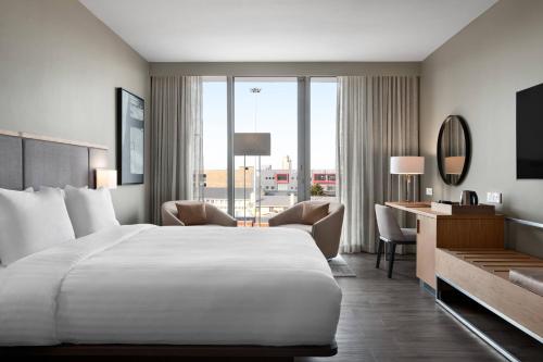 Habitación de hotel con cama blanca grande y escritorio. en AC Hotel by Marriott Cape Town Waterfront en Ciudad del Cabo