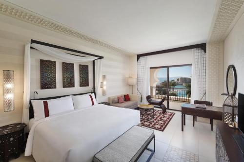 Al Manara, a Luxury Collection Hotel, Aqaba في العقبة: غرفة نوم بسرير ابيض كبير وبلكونة