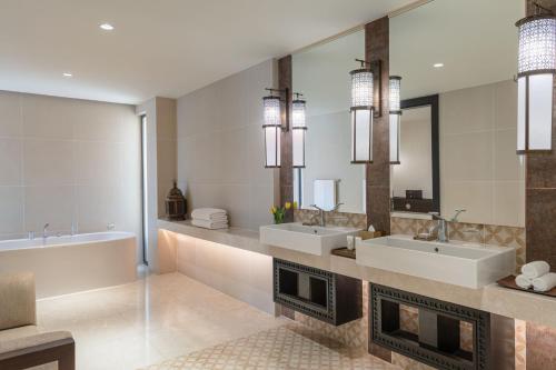 a bathroom with two sinks and a fireplace at Al Manara, a Luxury Collection Hotel, Aqaba in Aqaba