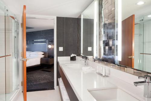 a bathroom with two sinks and a bedroom at Fremont Marriott Silicon Valley in Fremont