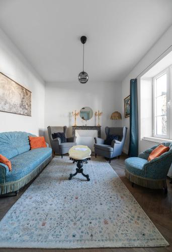a living room with blue couches and a table at La Grande Maison Gannat in Gannat