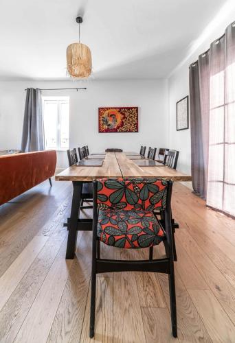 a dining room with a wooden table and chairs at La Grande Maison Gannat in Gannat